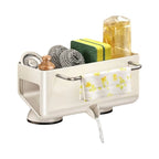 A cream-colored wall-mounted sink organizer with suction cups, shown holding various kitchen cleaning tools like a sponge, dishcloth, and bottle. The organizer features chrome handles and a floral-patterned white dishcloth hanging from the side.