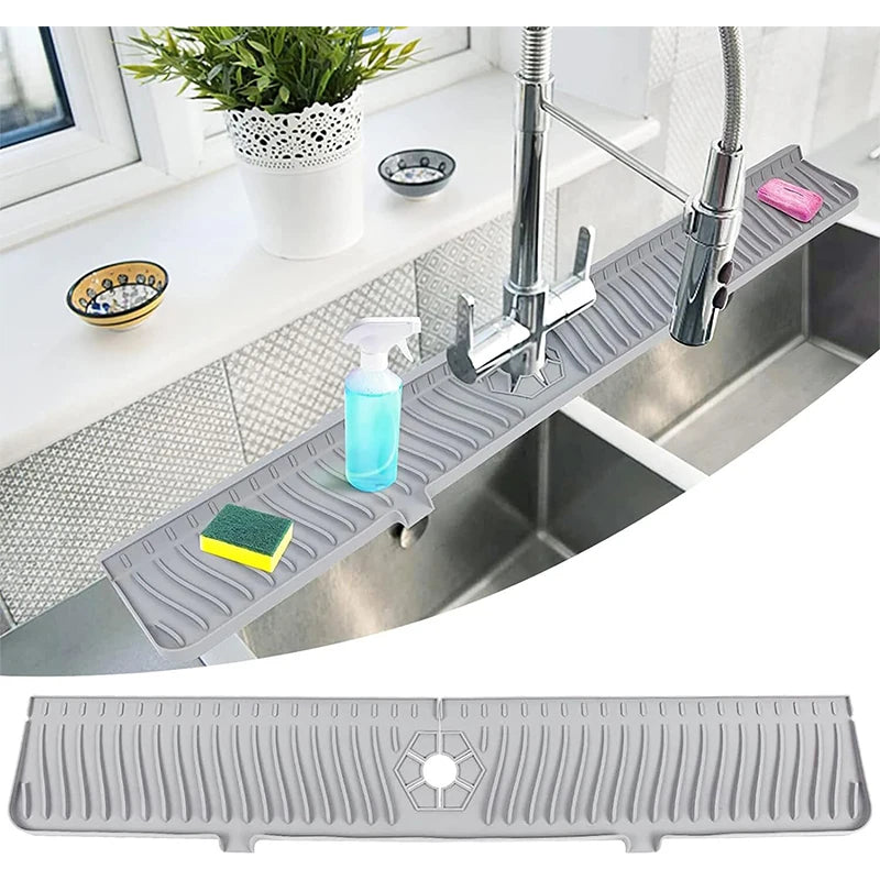 Gray kitchen sink mat on a kitchen counter with a window and plant in the background.