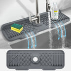 Gray silicone sink mat with water drainage holes in a kitchen setting.