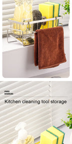 Kitchen cleaning tool storage rack with brown towel and sponges on a white cabinet.