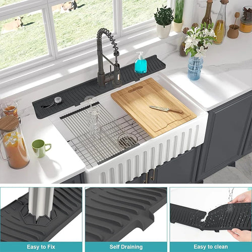 Kitchen sink setup with a black rubber mat, cutting board, and various kitchen items.