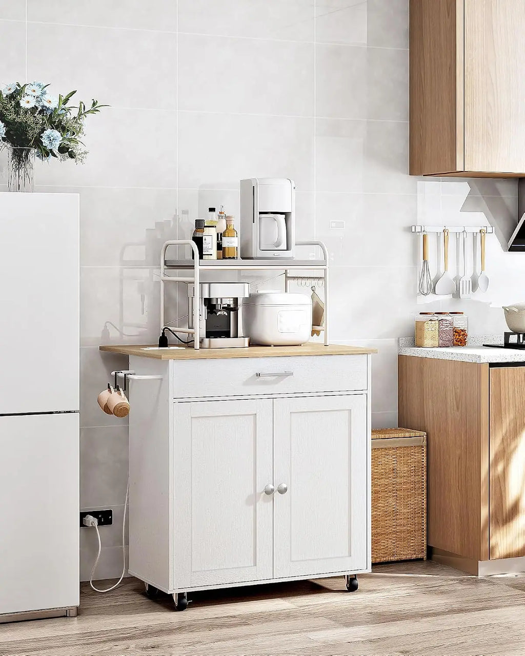 A white kitchen utility cart with a light wood top and two cabinet doors on casters, shown in a modern kitchen setting next to a refrigerator.