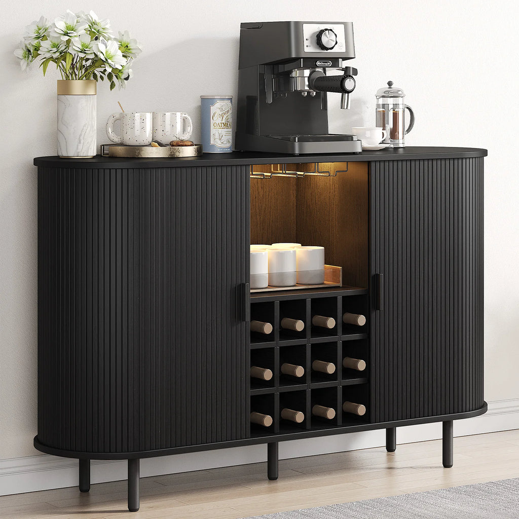 Black bar cabinet with wine storage and coffee-making equipment on a light wood floor.